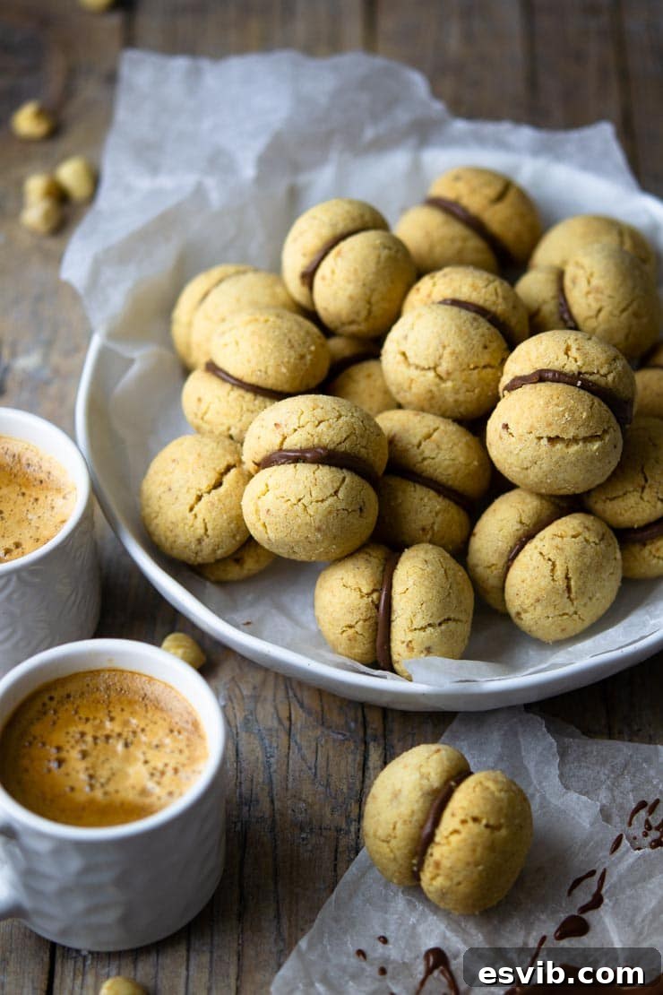 A close-up shot of Lady's Kisses cookies elegantly arranged in a bowl, with two cups of coffee subtly blurred in the background, highlighting their appeal as a coffee accompaniment.