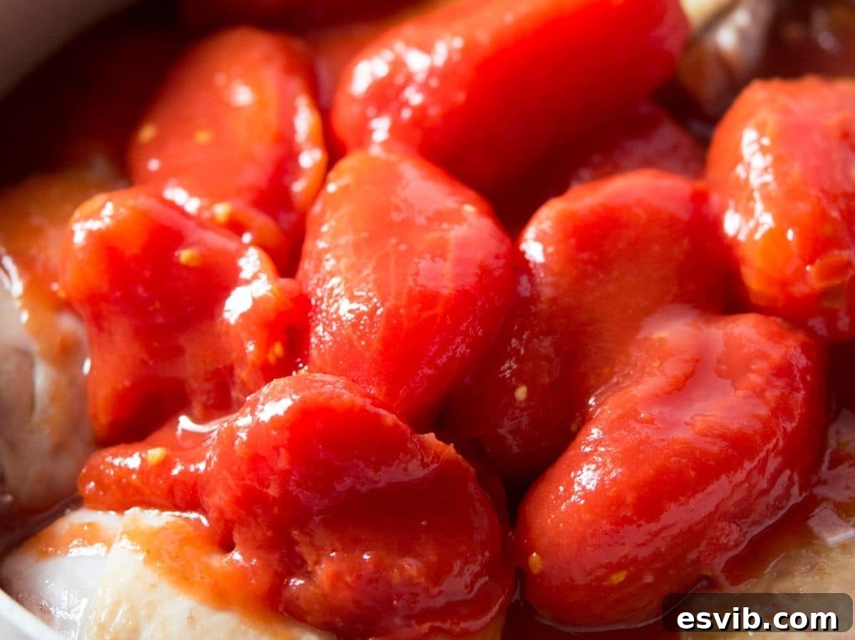Building Your Authentic Italian Pantry 3 A close up of canned plum tomatoes in a pot with chicken.