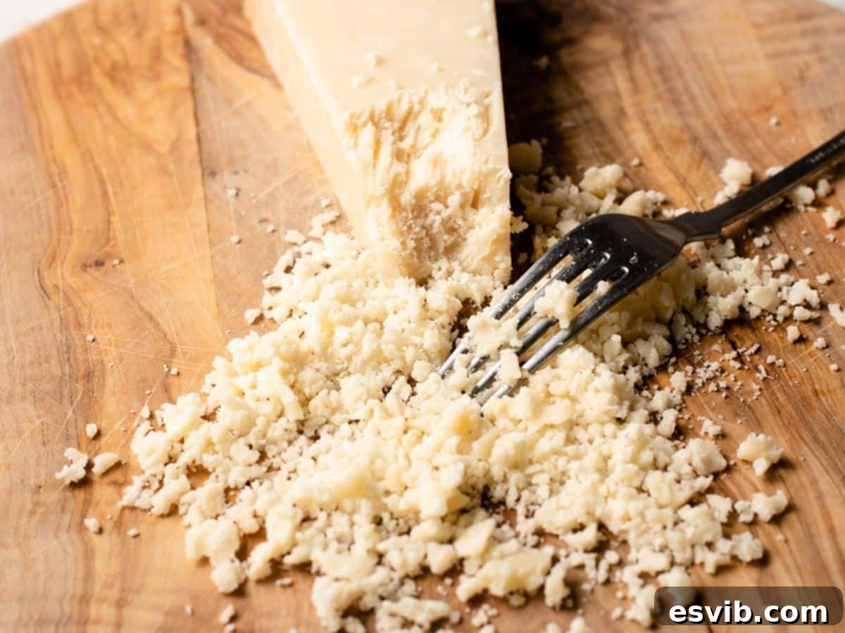 Building Your Authentic Italian Pantry 5 A close up of Parmigiano Reggiano being crumbled with a fork.