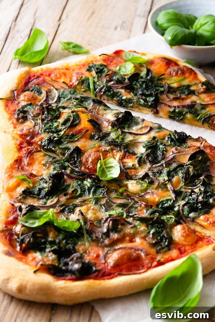 A close-up shot of a magnificent spinach pizza, expertly cut into pristine slices, beautifully showcasing the perfectly melted Gorgonzola cheese, the vibrant green wilted spinach, and the delicate, translucent rings of red onion.