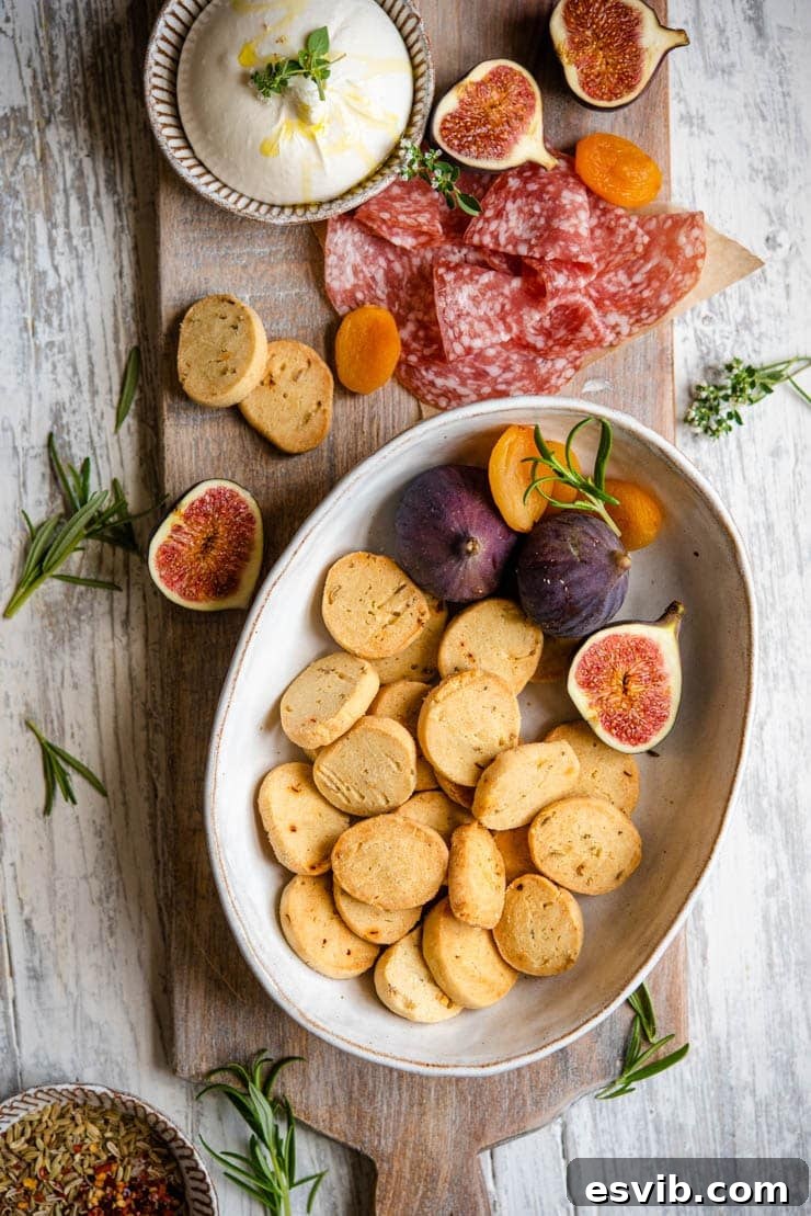 Parmesan Cheese Cookies: Savory Shortbread with Fennel and Red Pepper A bowl filled with golden-brown Parmesan Cheese Cookies, garnished with a few scattered fennel seeds, ready for serving.