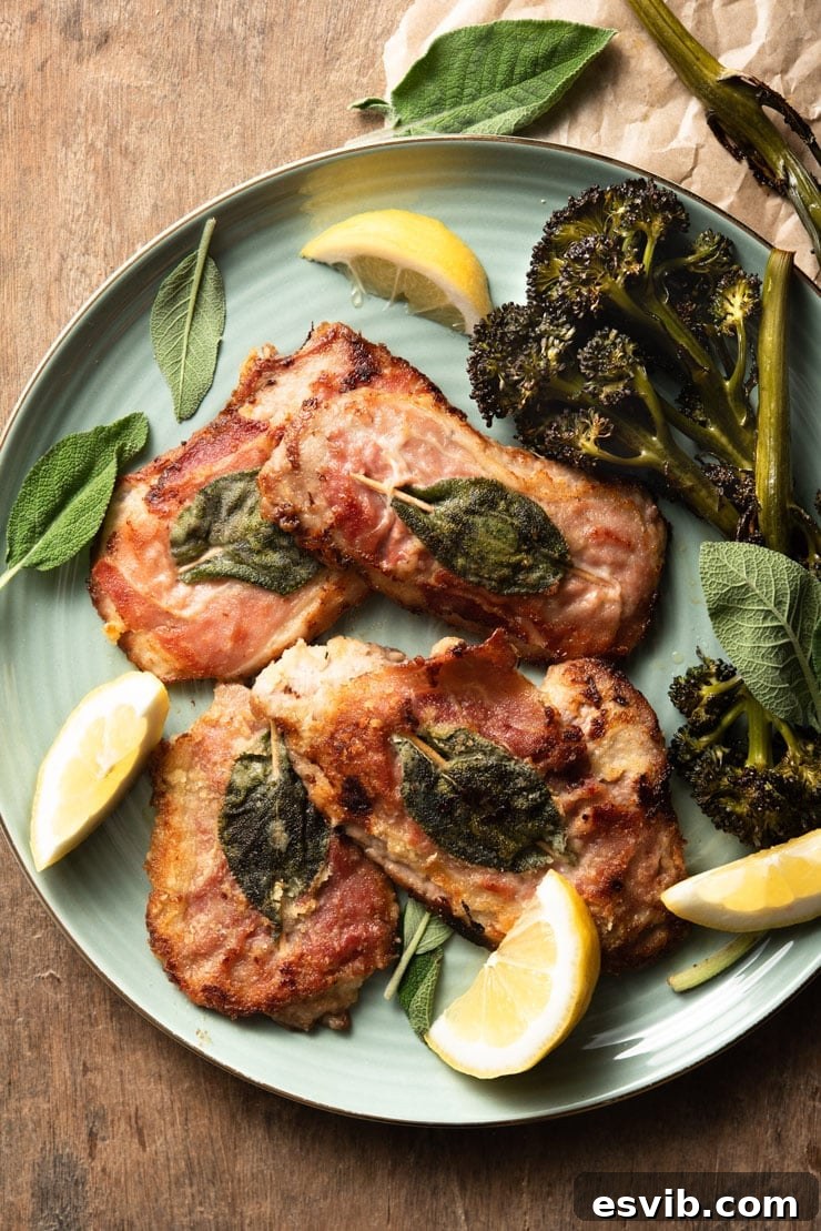An overhead shot of perfectly cooked Veal Saltimbocca on a plate, garnished with fresh sage, crispy prosciutto, and bright lemon wedges, ready to be served.