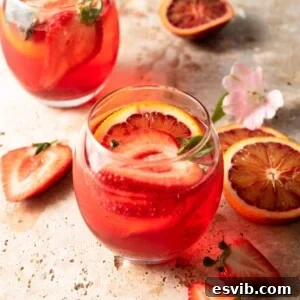Square image of a classic Campari Spritz cocktail garnished with fruit.
