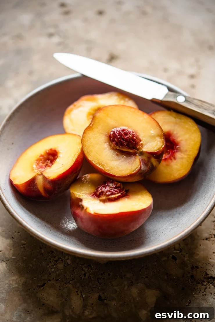 Fresh, ripe yellow peaches in a ceramic bowl, with a small paring knife resting beside them, ready for preparation to be turned into a delicious puree.