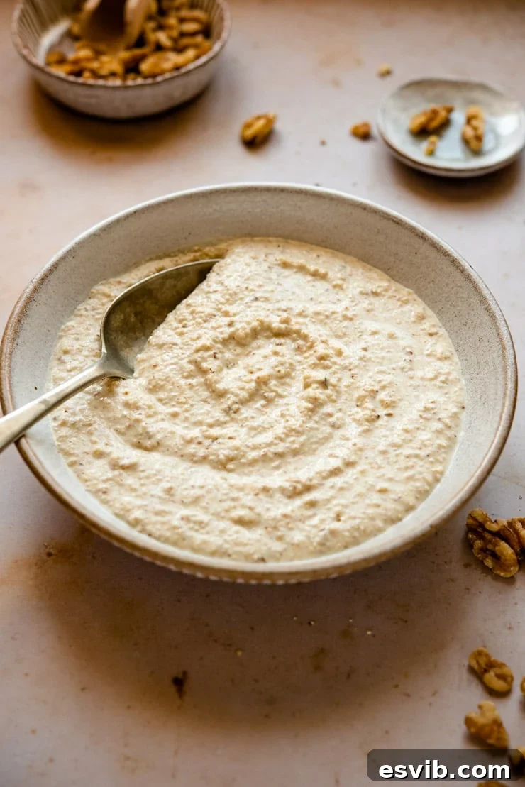 A rustic bowl filled with creamy homemade Italian walnut sauce, Salsa di Noci, ready to be used.
