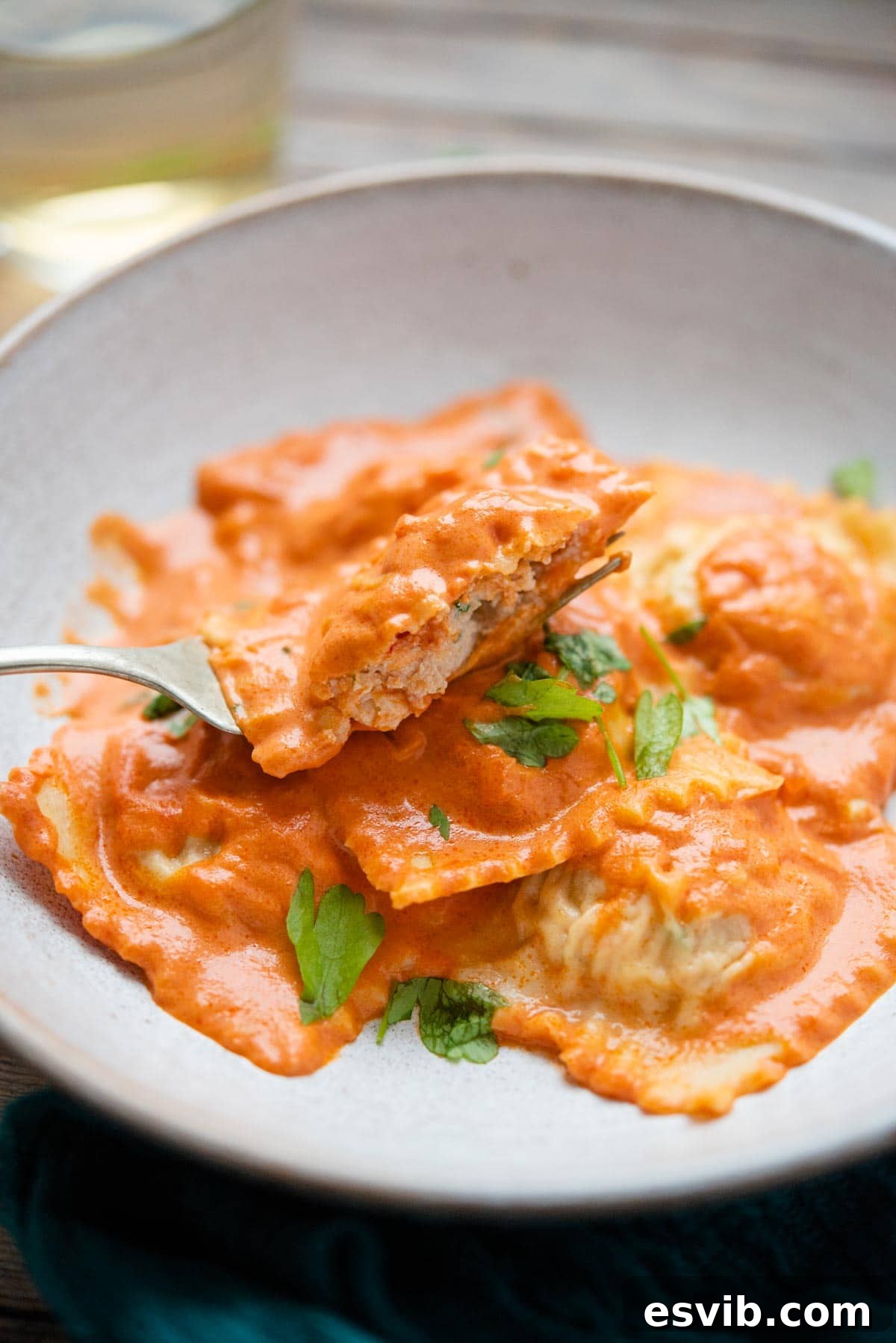 Decadent Lobster Ravioli with Velvety Vodka Sauce 9 A close up of lobster ravioli cut in half on a fork, showing the filling