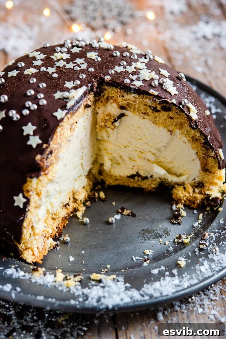 A close up of a panettone bomb Christmas ice cream cake with a slice cut out, revealing the panettone and semifreddo layers.