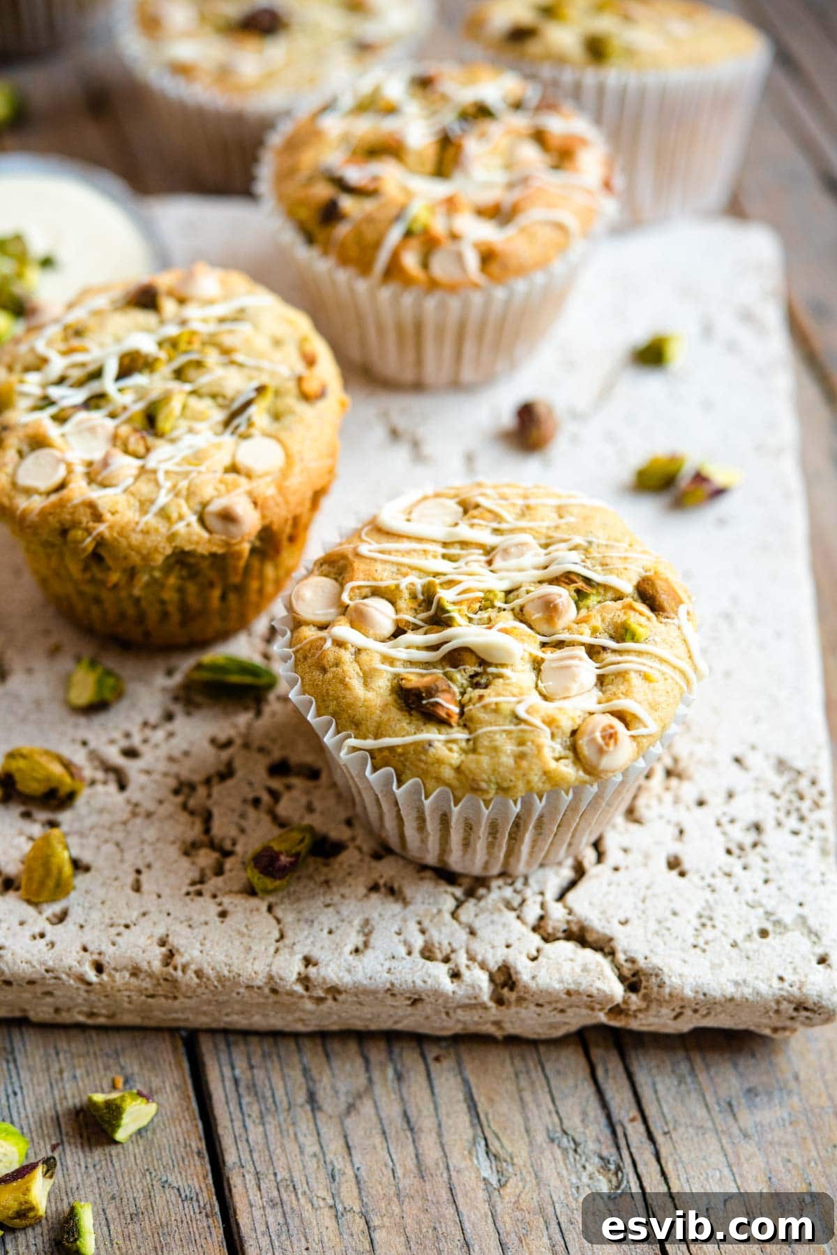 Emerald & Ivory Muffins 2 A close up of a pistachio muffin topped with white chocolate chips