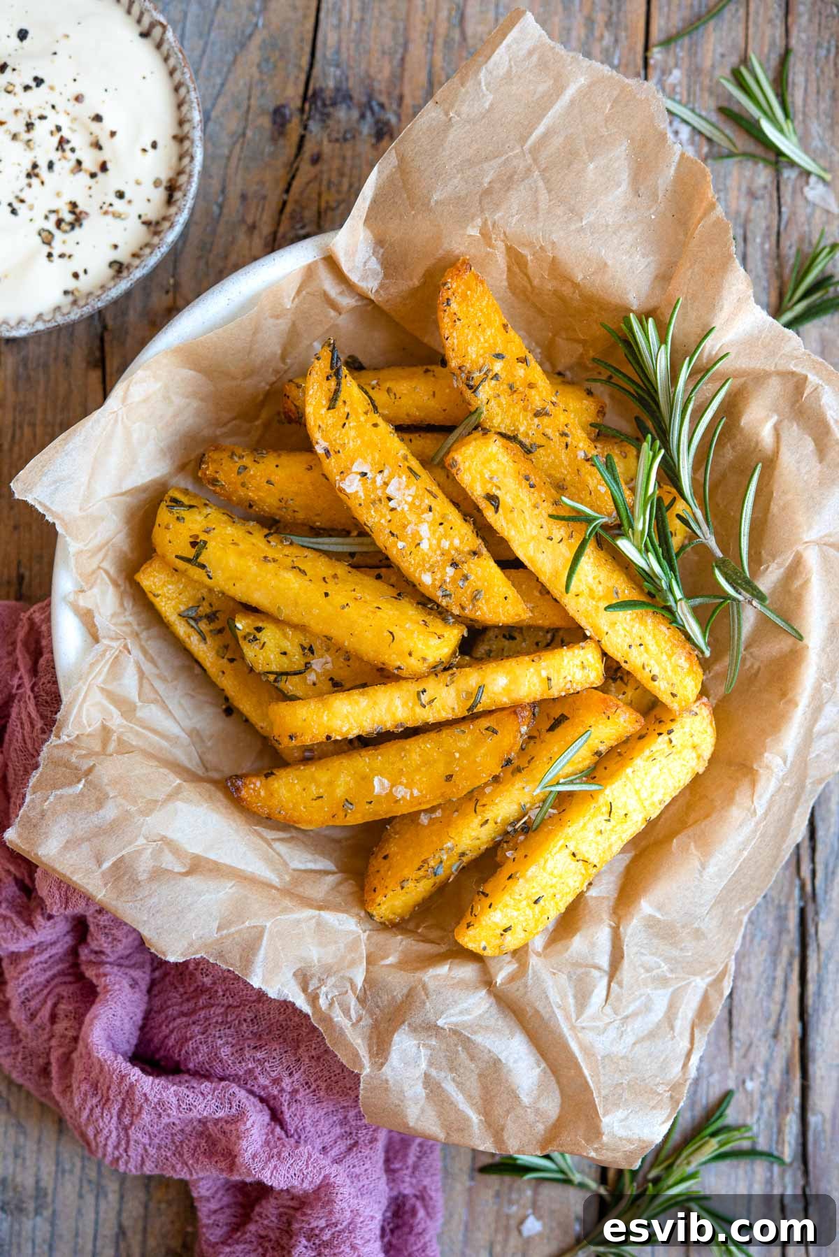 An overhead shot of golden brown polenta fries seasoned with herbs, served in a rustic bowl, ready for dipping.