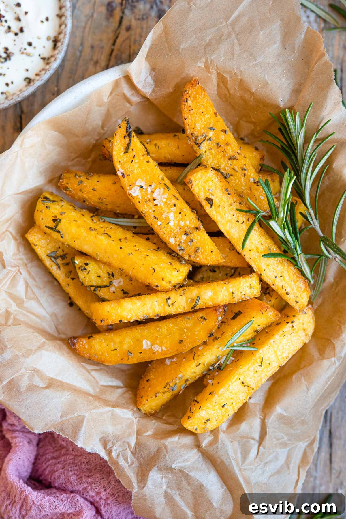 A close-up view of firm polenta, expertly cut into uniform fry shapes, arranged in a bowl with fresh rosemary sprigs.