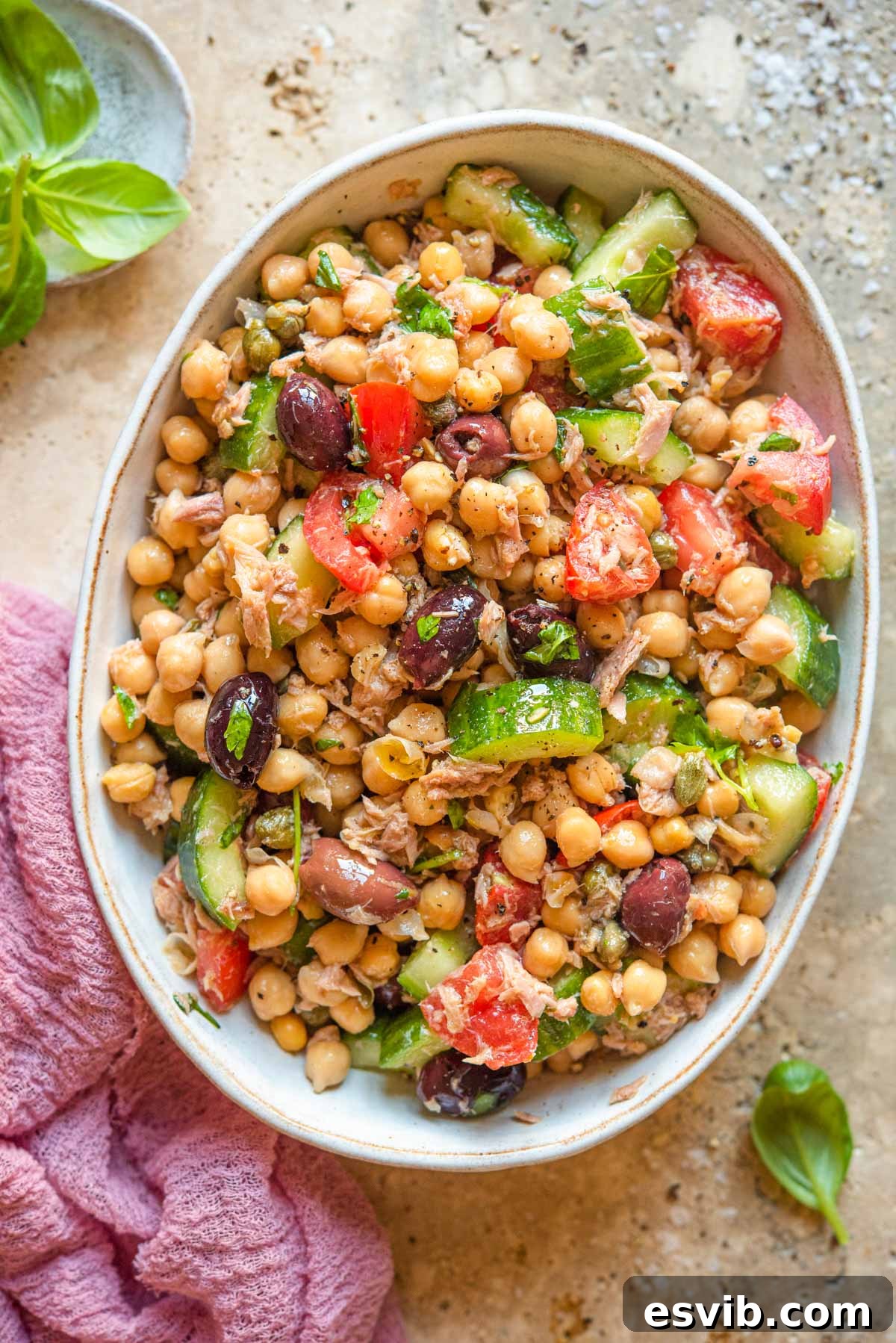 An overhead shot of a vibrant Chickpea Tuna Salad with chickpeas, tuna, and tomatoes in a large bowl, ready to be served.