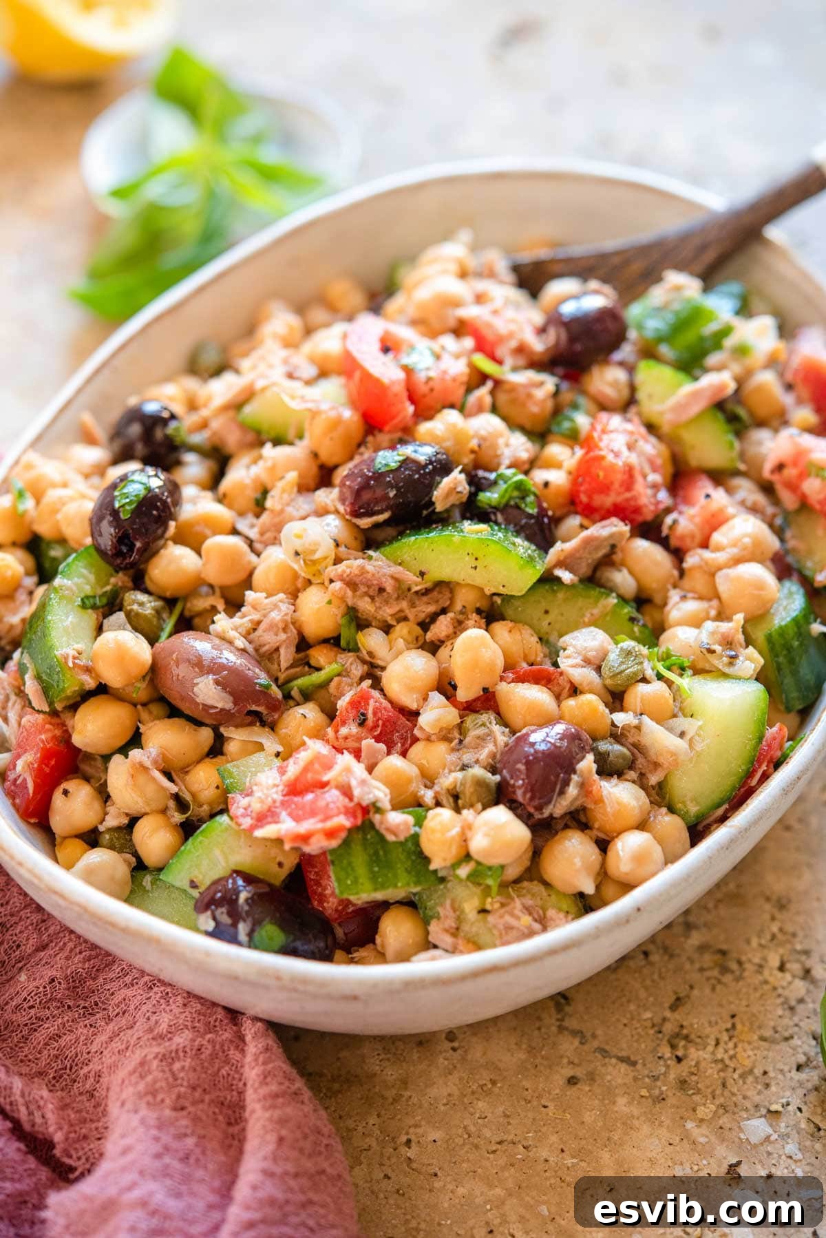 A side shot of a perfectly mixed chickpea tuna salad in a large bowl, showcasing its colorful and fresh appearance.