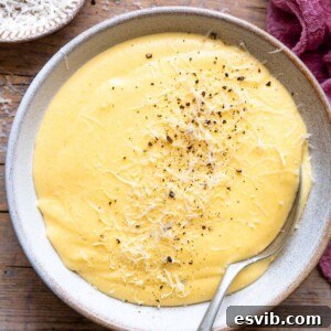 A square image of creamy polenta in a bowl, ready to serve