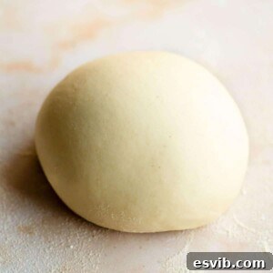 A close-up of semolina pasta dough in a ball on a marble surface