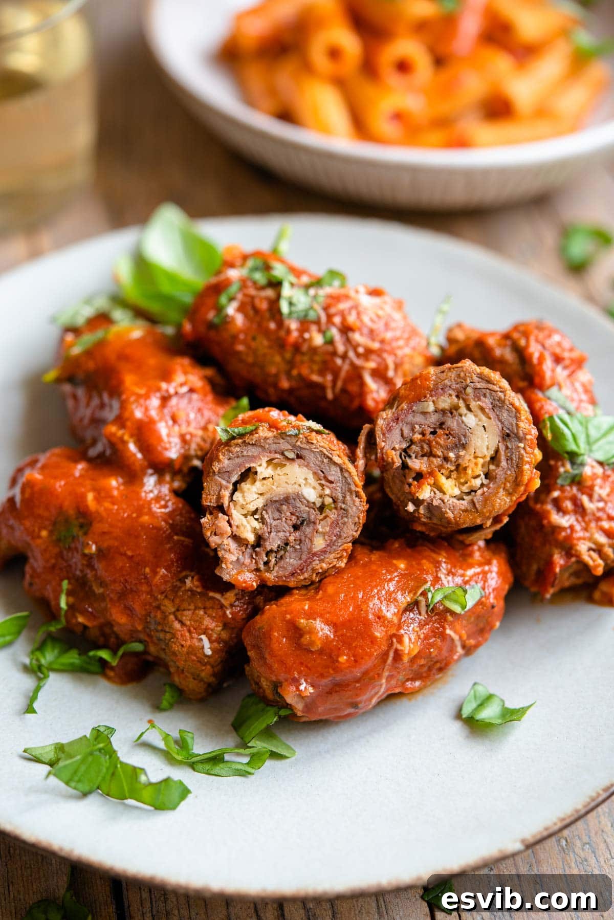 A close up of beef braciole cut in half so you can see the filling