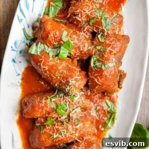 An overhead shot of beef braciole on a platter with tomato sauce