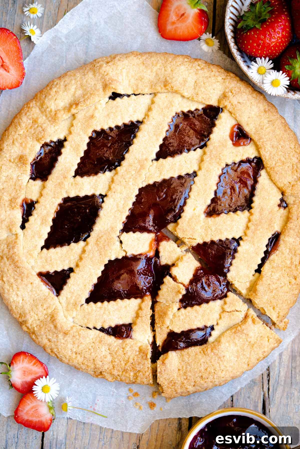 Classic Italian Jam Crostata 2 An overhead shot of a freshly baked Italian jam crostata with a golden lattice top and a slice already cut, revealing the rich, vibrant fruit filling.
