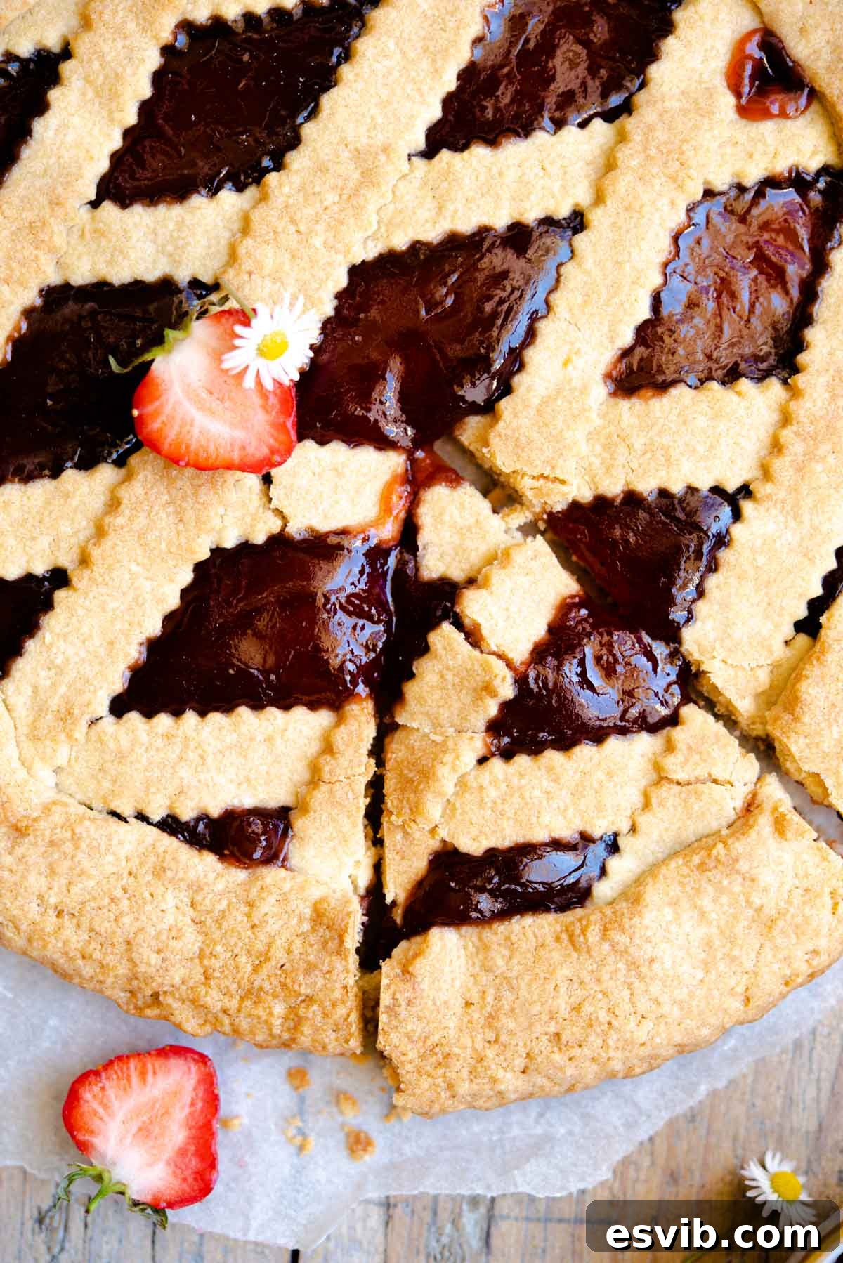 Classic Italian Jam Crostata 6 A vibrant, close-up, overhead shot of a freshly baked Italian jam tart, showcasing its intricate pastry lattice and the glistening, rich fruit filling beneath.