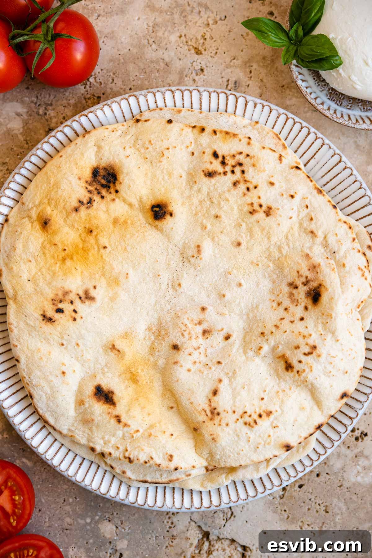 Piadina: Italy's Signature Flatbread 7 An overhead shot of multiple cooked Italian flatbreads arranged on a rustic plate, ready to be filled.