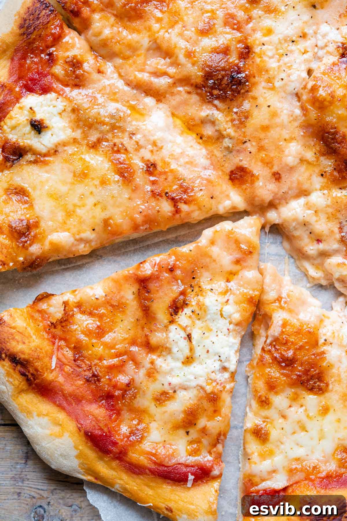 Four Cheese Pizza 7 A close-up shot of a single slice of Quattro Formaggi pizza, showing the rich, melted cheese pull and the perfectly golden, crispy crust.