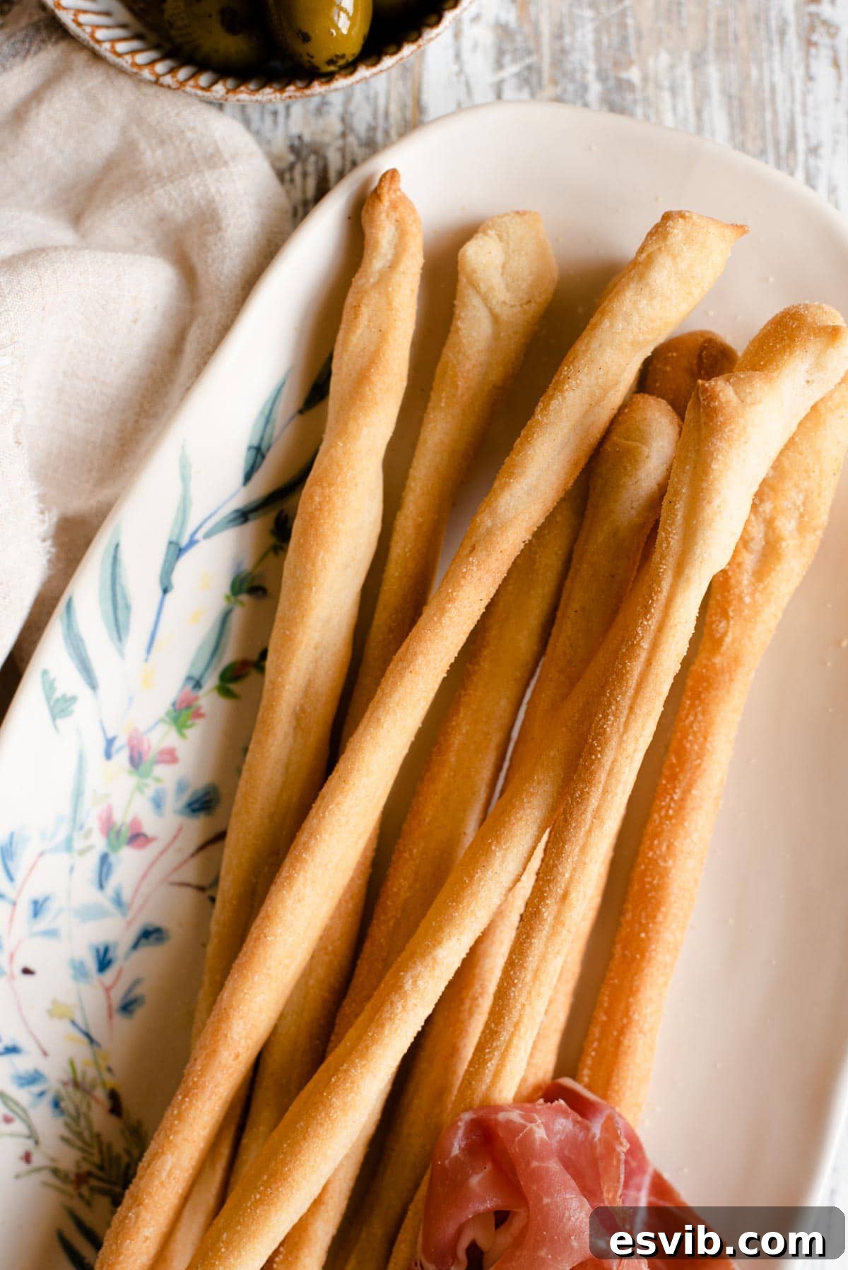 Grissini: Italy's Signature Crispy Breadsticks 5 A beautiful close-up shot of freshly baked Italian Grissini breadsticks, showcasing their perfectly golden color and irresistible crispy texture, elegantly presented on a serving plate.