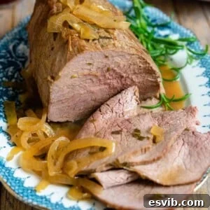 A close up of roast beef on a plate, showcasing the tenderness and rich color.