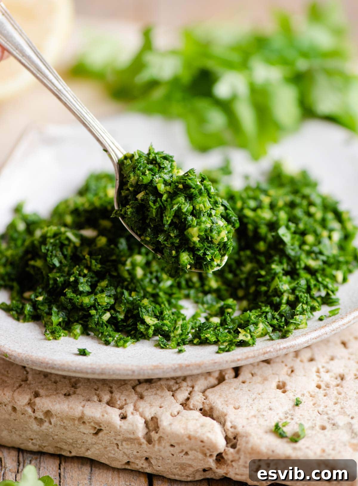 Zesty Italian Herb Gremolata 5 A close-up shot of a small spoon holding a serving of vibrant green Gremolata, ready to be added to a dish.