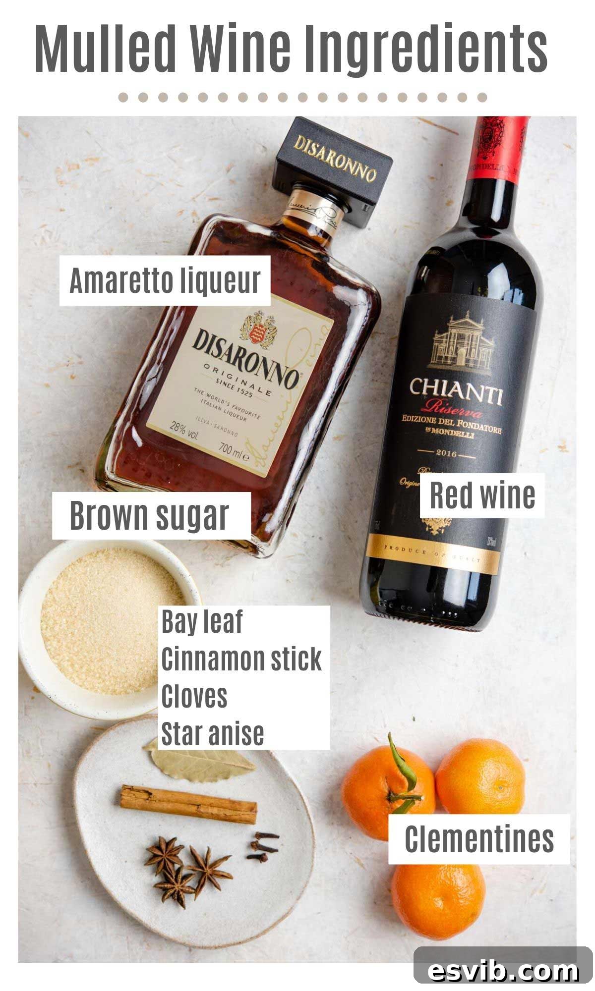 An overhead shot of all the ingredients you need to make mulled wine, including red wine, clementines, spices, and amaretto