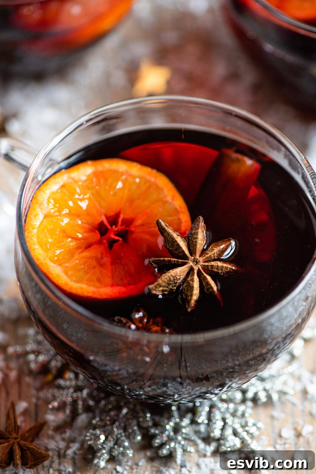 A close up of a mug of mulled wine with oranges, star anise and cinnamon, ready to be enjoyed