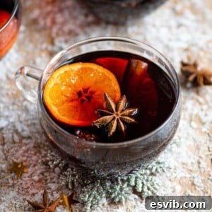 Mulled wine in a glass mug with orange and star anise inside it