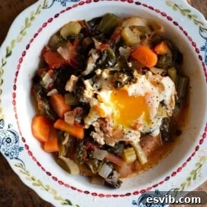 A close-up cropped image of Acquacotta soup topped with a poached egg in a bowl, showcasing its delicious texture and presentation.