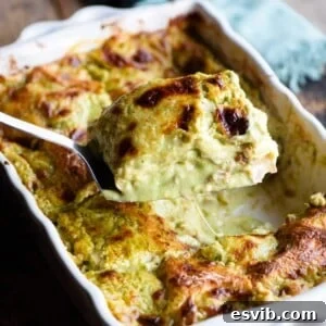 A close up of a spatula picking up a slice of pistachio lasagna from a baking dish.
