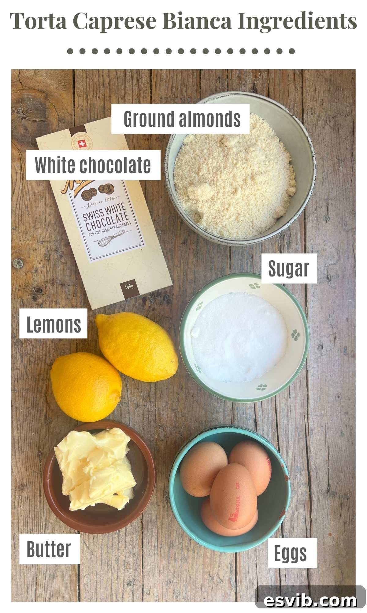 An overhead shot of all the ingredients needed to make a torta caprese bianca laying out on a rustic wooden surface.
