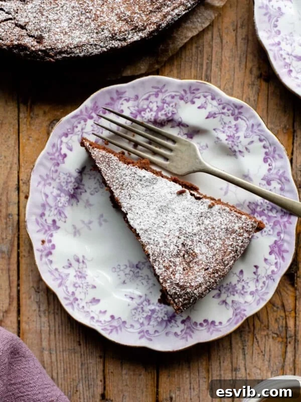 An overhead shot of a slice of chocolate torta caprese on a pink patterned plate