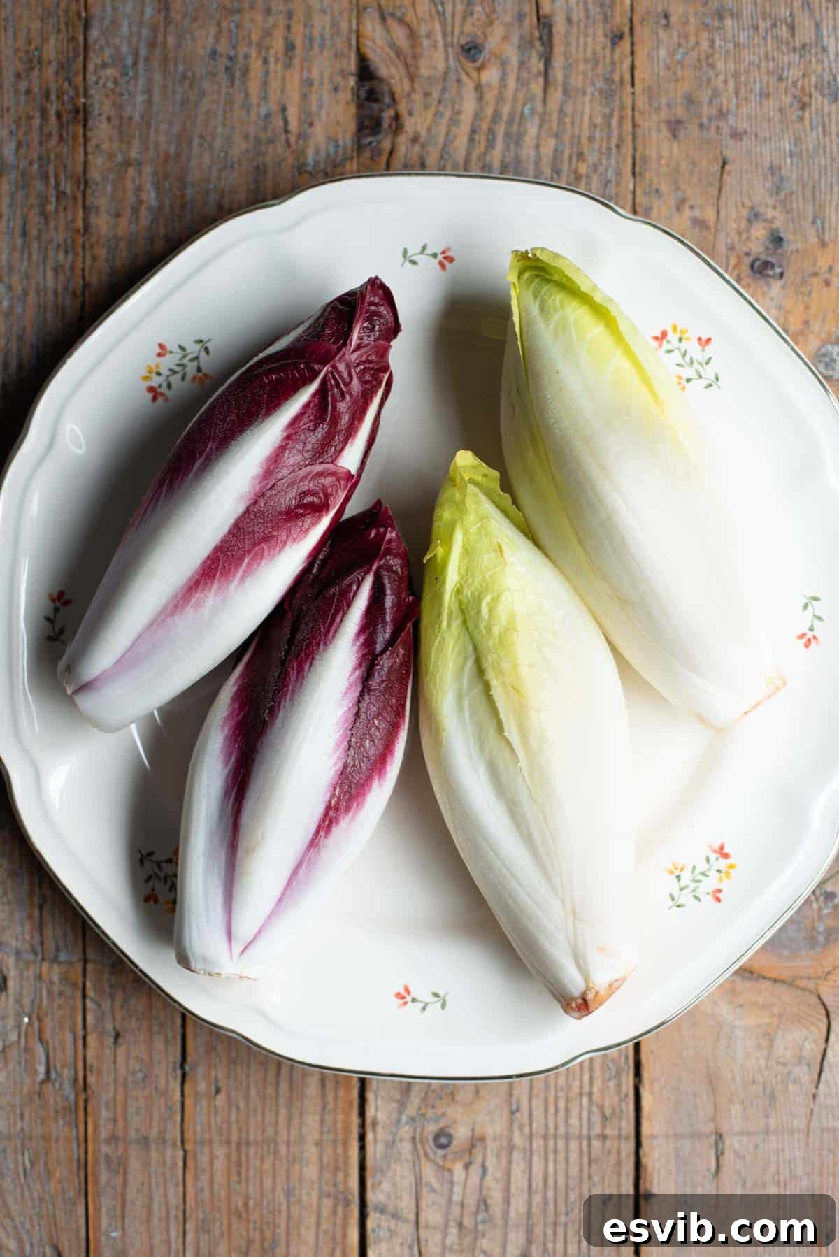 An overhead shot of red and white chicory on a plate with a rustic wooden background.