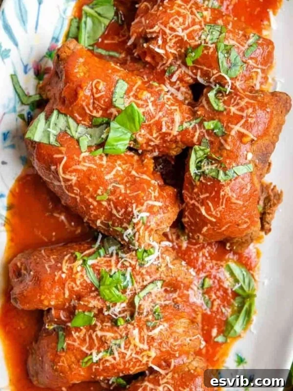 An overhead shot of beef braciole on a platter with tomato sauce