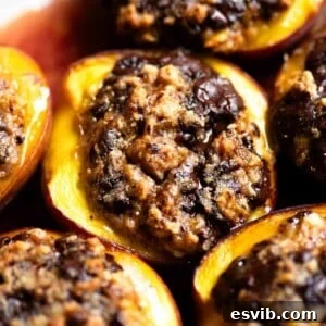 A close up of a baked peach stuffed with amaretti cookies and chocolate.