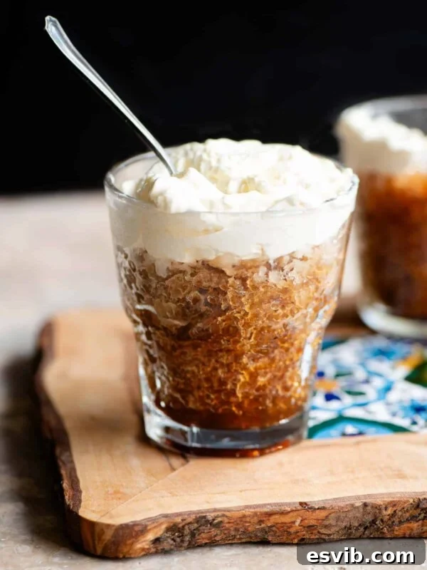 Caffe Shakerato: Classic Italian Iced Coffee Recipe 7 A small glass of coffee granita topped with whipped cream and a spoon in it.