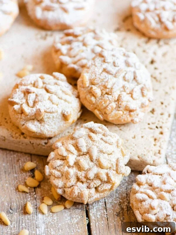 Italian Abbracci Chocolate and Cream Cookies 5 Pignoli cookies on a wooden surface dusted with powdered sugar